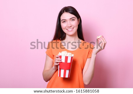 girl with popcorn on a colored background. Watch a movie, 3D movie.
