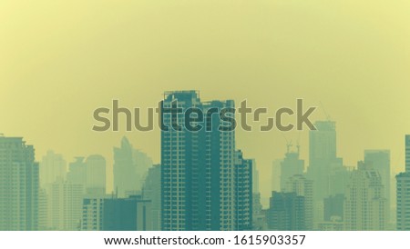 cityscape of high rise buildings in poor weather morning, haze of pollution covers city, global warming and climate change concept