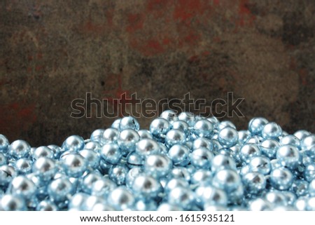 A scattering of blue beads on a background of a beautiful dark marble surface. Background surface for decoration
