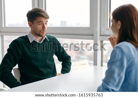 Work colleagues sitting at the desk chatting office