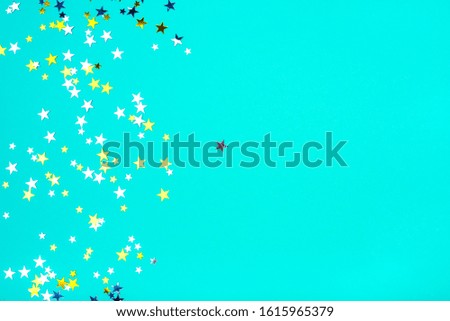 Golden and silver stars on mint background. Flat lay, top view.