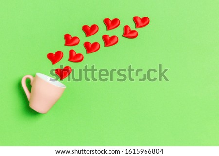 Top view of red textile hearts splashing out of a cup on colorful background. Happy Valentine's day concept.