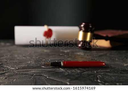Notary and law concept. Stamp with book and pen on the table. Wooden gavel behind.