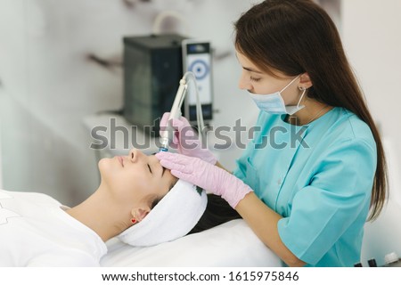 Professional female cosmetologist doing hydrafacial procedure in Cosmetology clinic. Doctor use hydra vacuum cleaner. Rejuvenation And Hydratation. Cosmetology Royalty-Free Stock Photo #1615975846