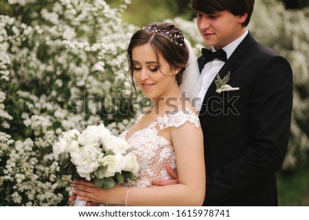 Handsome groom staind in front of beutiful bride