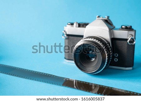 Film camera on a blue background, film for the camera