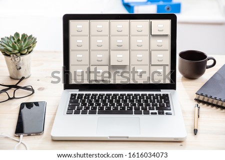 Files digital archive, data storage concept. Filing cabinets on a laptop screen, business office background  Royalty-Free Stock Photo #1616034073