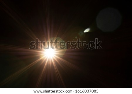 Lens Flare effect. Yellow light over black background. Abstract sun burst with bokeh. Easy to add overlay or screen filter over photos and images. Copy space. Star, space concept.
