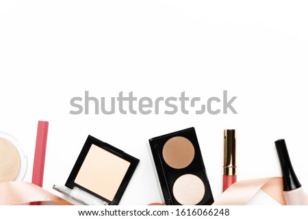Make up products from above horizontal border on white background. Blusher, face powder container, eyebrow shadow and lip gloss. Decorative cosmetics backdrop. Female glamour beauty products