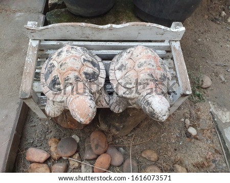 Two concrete turtles statue which sitting on bench in the garden
