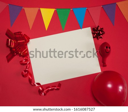 The concept of birthday. Paper blanks, a garland of triangular flags, streamers, balloons and bows for gifts on a red background. Free space.