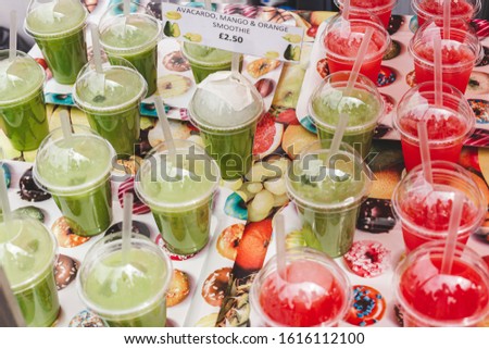 Close up of a variety of smoothies on sale in a stall in a food market. Smoothie is a thick and creamy beverage made from pureed raw fruit or vegetables