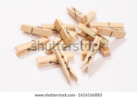 Heap of wooden clothes pins on white background. Top view.