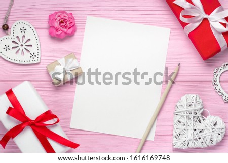 Top view holdiay composition with hearts, rose flowers, gift boxes and blank copybook on pink wooden background to write greetings, st. Valentine's flatlay. Mock up, copy space.