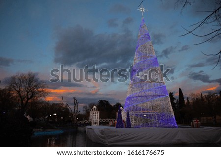 Christmas lights tree at the lake during a colorful sunset
