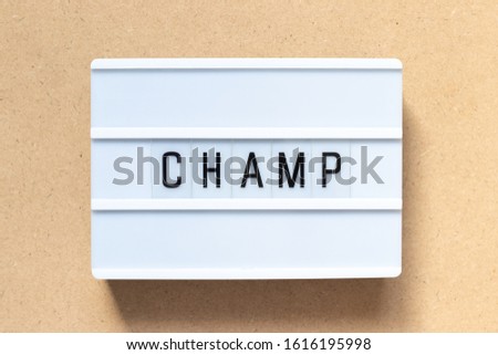 White lightbox with word champ on wood background