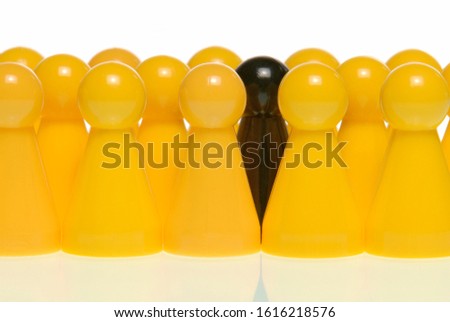 A black figure surrounded by yellow figures, symbolic image for the black sheep in the group