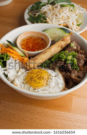 Pho soup. Vietnamese traditional classic soup made from beef stock and fresh vegetables. Soup simmered for hours and garnished with scallions, cilantro basil and bean sprouts & topped w/ a fried egg.