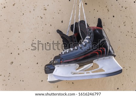Winter sports skates hang on a wall as a symbol of career completion