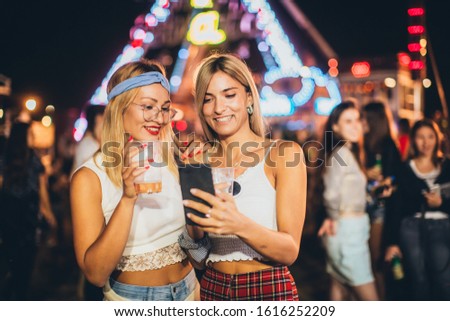 Two girls taking selfie in the amusement park