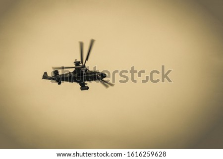 Helicopter in the cloudy sky, view from below. Martial law, conflict in the Middle East. Military pilot. Toning. Vignetting.