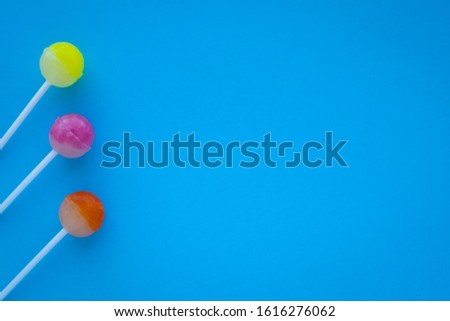 colorful lollipops on white, blue background