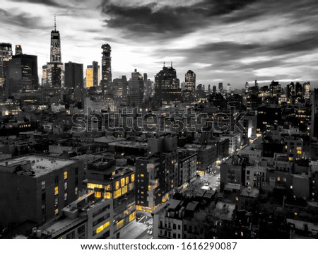 New York City skyline view at night with yellow lights contrasted against the black and white buildings of lower Manhattan