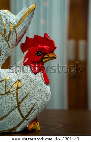 Partial and selective focus image of a pair of white wooden chicken statues with red heads. Photographed from a short distance, suitable for decoration and souvenirs.