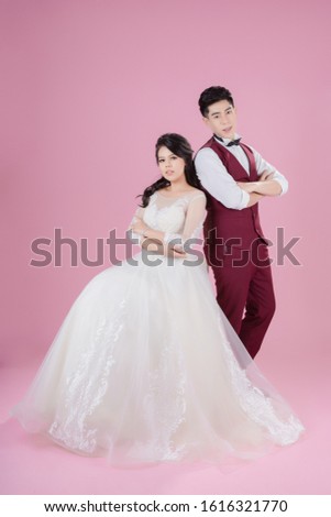 Happy young bride and groom on the pink background. Wedding couple, new family, wedding dress. Bridal wedding. Love concept