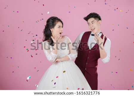 Happy young bride and groom with glitter on the pink background. Wedding couple, new family, wedding dress. Bridal wedding. Love concept.