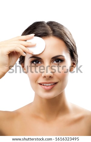 Portrait of happy smiling beautiful young woman cleaning skin by cotton pad, isolated over white background