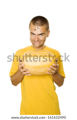 Young man holds a lot of different pumpkin in his hands