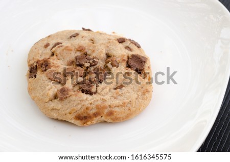 Close up picture of fresh baked chocolate cookies on white dish.