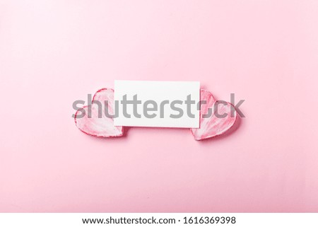Blank greeting card with valentine hearts on pink background. Symbol of love and holiday Valentine's Day. Minimalism concept, template for congratulations. Top view, place for text.