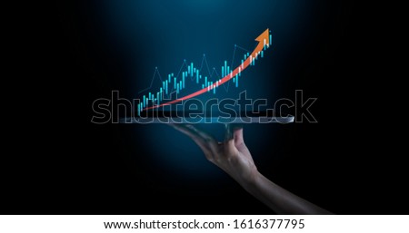 Business evolution to success and growing growth concept.hand holding an empty digital tablet with growth stock graph and rising arrow,Corporate representing business growth. Royalty-Free Stock Photo #1616377795