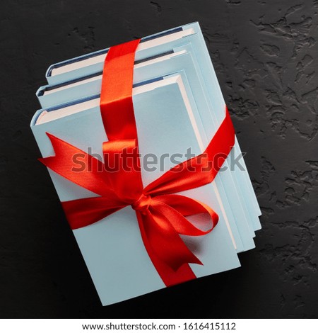 Top view stack of books tied with ribbon on a dark background with copy space.