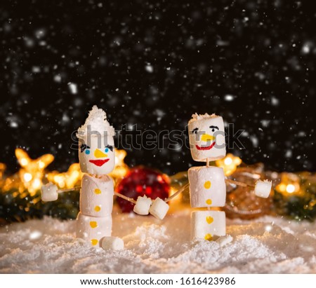 Marshmallow snowmen holding hands. Holiday concept. Christmas background with sweets.