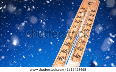 Wintertime. Winter background. Thermometer on snow shows low temperatures.