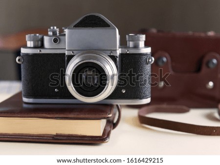 Old film camera and notebook on the table. Vintage photography