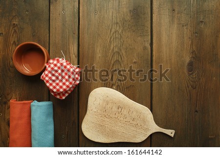 Kitchen table/Cookbook background. An old wooden kitchen table. Kitchen plank, bowl, kitchen towel and jar.