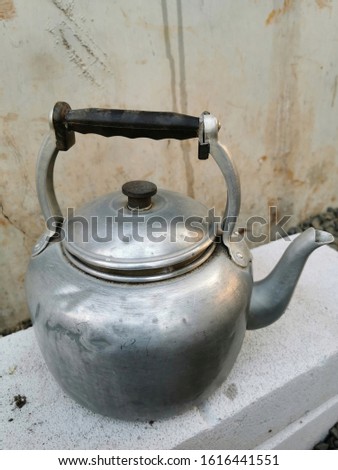 Silver teapot is on the stone.