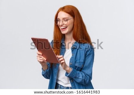 Waist-up porrtrait happy cheerful redhead girlfriend talking to partner using internet video-call service, laughing happily, having fun, smiling at gadget camera, standing white background