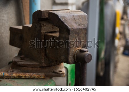 An old rusty vise, located in the inner yard of the old village house. Workshop concept. Tools and hardware for everyday. Construction and repair. Selective focus