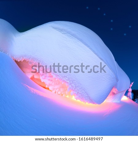 snow cornice at the top is a snow formation formed in the mountains under the influence of wind. Artistic illumination has created a fabulous fiction picture, Big Dipper constellation