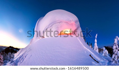 snow cornice at the top is a snow formation formed in the mountains under the influence of wind. Artistic illumination lamp has created a fabulous fiction picture