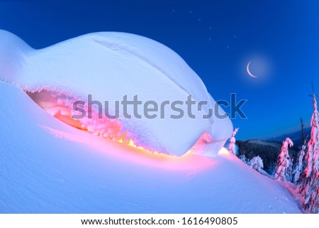snow cornice at the top is a snow formation formed in the mountains under the influence of wind. Artistic illumination has created a fabulous fiction picture, Ursa Major constellation