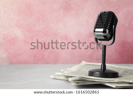 Newspapers and vintage microphone on table, space for text. Journalist's work Royalty-Free Stock Photo #1616502865