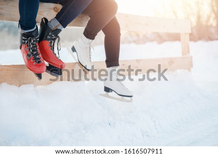 Closeup winter skates on transparent ice rink. Couple in lover.