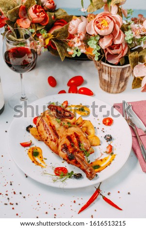 grilled chicken with potatoes on a decorated white table