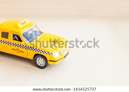 Simply design yellow vintage retro toy car Taxi Cab model on wooden background. Automobile and transportation symbol. City traffic delivery urban service idea concept. Copy space